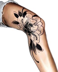 a woman's leg with tattoos and flowers on her arm, which are black and white