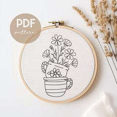 a potted plant with daisies in it on a white table next to some dried flowers