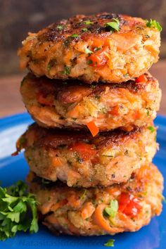 three crab cakes stacked on top of each other with garnish and parsley