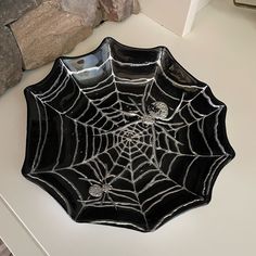 a black spider web bowl sitting on top of a counter