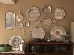 there are many plates and silverware on the shelf in this room, including dishes