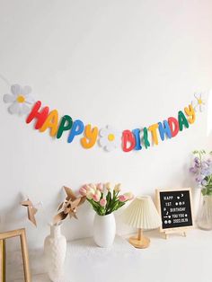 a happy birthday banner is hanging on the wall next to vases and other decorations