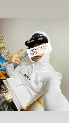 a person wearing a white hoodie and blindfolded head covering with the word jevens printed on it