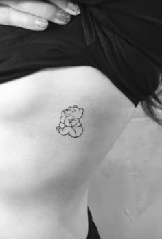 a woman's stomach with a small tattoo of a teddy bear on the side