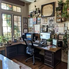 a home office with lots of pictures on the wall and desks in front of it