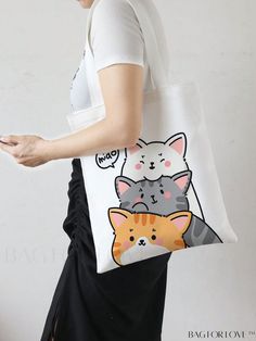 a woman carrying a tote bag with two cats on the front and one cat on the back