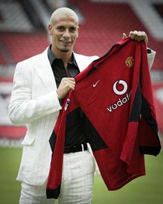 a man holding up a red shirt and white pants