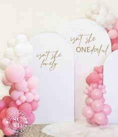 some balloons are in front of two white signs and one pink balloon is on the floor