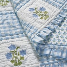 two blue and white bedspreads with flowers on them, one has a ruffled edge