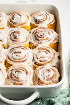 a pan filled with cinnamon rolls covered in icing