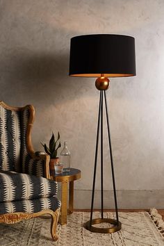 a living room with a chair, lamp and rug on the floor in front of it