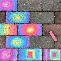 the sidewalk is made out of colored bricks and chalk crayons on top of it