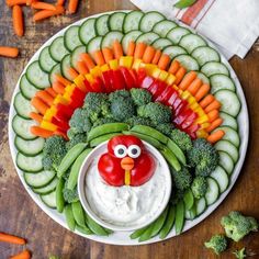 a platter with vegetables, veggies and a turkey face painted on it