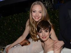 two women sitting next to each other at a table