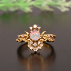 an opal and diamond ring on a black surface