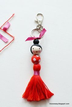 a keychain with a doll hanging from it's side on a white surface