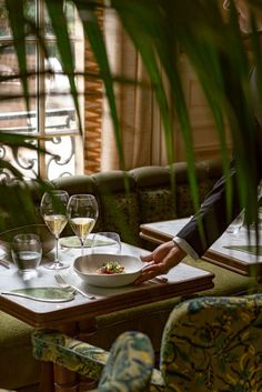 a woman sitting at a table with two glasses of wine