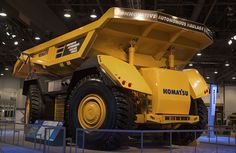 a large yellow dump truck on display in a building