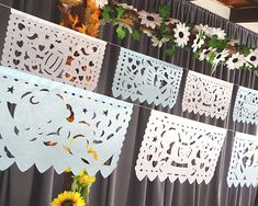 paper cutouts are hanging on a curtain with sunflowers in the foreground