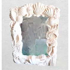 an ornate white frame with seashells on it