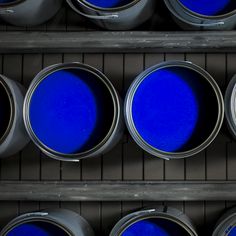 several blue paint cans lined up in a row