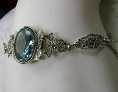 "<> (Made To Order) This is a brand new Victorian/Art Deco Reproduction filigree sterling silver gemstone bracelet. The gorgeous 6ct oval cut Simulated/man-made aquamarine gemstone is 14mm x 10mm x 6mm in dimension. Notice the beautiful craftsmanship of the filigree settings and links. This is a well made beautiful bracelet and it is ready to wear. The bracelet is adjustable and will fit from 7\" to 8.5.\"The color and clarity of each gemstone are excellent. A gift-box is included for safe Estate Silver Oval Jewelry, Antique Oval Link Bracelet For Formal Occasions, Estate Oval Jewelry For Gifts, Ornate Oval Engraved Bracelets, Vintage Blue Oval Bracelets, Vintage Blue Oval Bracelet, Estate Oval Jewelry For Wedding, Formal Oval Bracelet With Engraving, Formal Oval Bracelets With Engraving