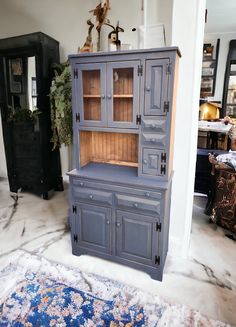 a blue china cabinet sitting on top of a rug