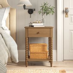 a bedroom with a bed, nightstand and basket on the side table in front of it