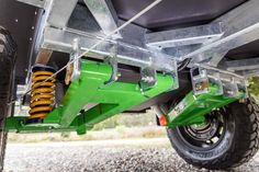 the rear end of a green truck with suspensions