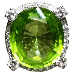 This absolutely spectacular cocktail ring is centered by a very impressive 18.53ct natural, bright electric green peridot surrounded by 1.08cttw in G-H color Vs1-2 clarity round diamonds. All stone weights are stamped inside of the shank. Dimensions/Weight: Ring measures .90” by .75” and weighs 19.7g. Size 6.5 (sizable). Condition: All stones are secure and in perfectly wearable condition. R-GASV Ballerina Ring, Christmas Photo Album, Electric Green, Baguette Diamond Rings, Peridot Stone, Diamond Cocktail Rings, Modern Ring, Green Peridot, Christmas Photo