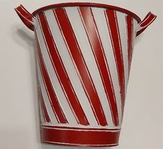 a red and white striped cup hanging on the wall