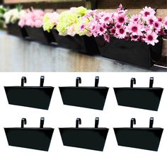 six black flower pots with pink and green flowers in them