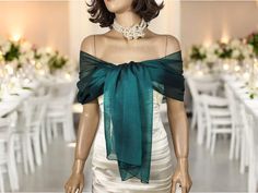 a mannequin dressed in a dress with a green bow around it's neck