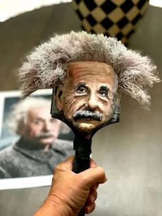 a person holding a hair dryer with an image of albert monroe on it's head