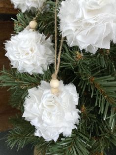 some white flowers hanging from a christmas tree