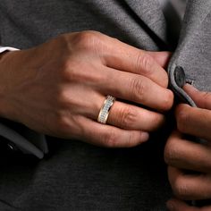 a man in a suit and tie wearing a wedding band