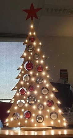 a lighted christmas tree sitting on top of a desk