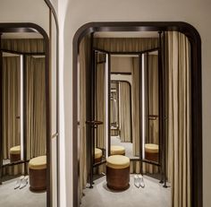 a room with mirrors, stools and drapes on the walls in front of it