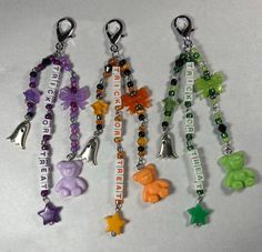 six different key chains with charms attached to each one's sides and words on them