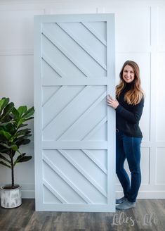 a woman is standing behind a large white door