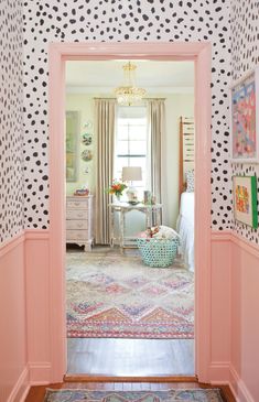 an open door leading to a bedroom with polka dot wallpaper