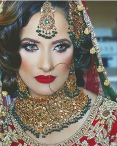 a woman wearing a red and gold bridal outfit