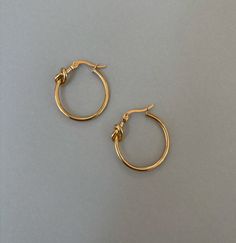 SMALL GOLD KNOT HOOP EARRINGS Materials: Stainless steel, 18K gold plated Stud Measurements: 23mm inner diameter, 25mm outer diameter, 1.5mm thickness Closure: latch back Additional Info: High polish Finish Hypoallergenic Eco-friendly: We use sustainable metals and recycled gold tarnish resistant and waterproof All of our gold jewelry is plated with recycled gold. Each piece is coated using the highest grade technique, which is made to be 8 times more durable than traditional gold-plated jewelry Traditional Small Hoop Earrings, Sample Sale, Recycled Gold, Gold Plated Jewelry, Sale Items, Final Sale, Gold Jewelry, 18k Gold, Gold Plate