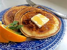 pancakes with butter and orange slices on a blue plate