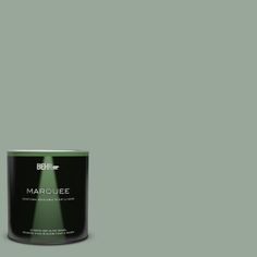 a can of behr marquee paint on a green background