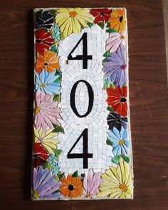 the number four is made out of mosaic tiles with flowers and leaves on it's side