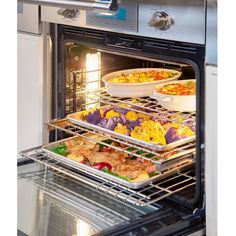 two trays of food are being taken out of the oven and into the oven