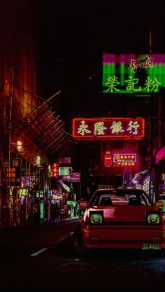 a car parked on the side of a street at night with neon signs above it