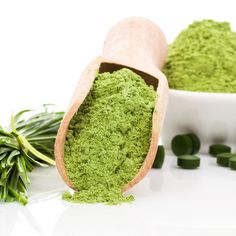 green powder in a white bowl next to herbs