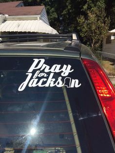 a car with the words pray for jackson written on it's back window, parked in front of a house